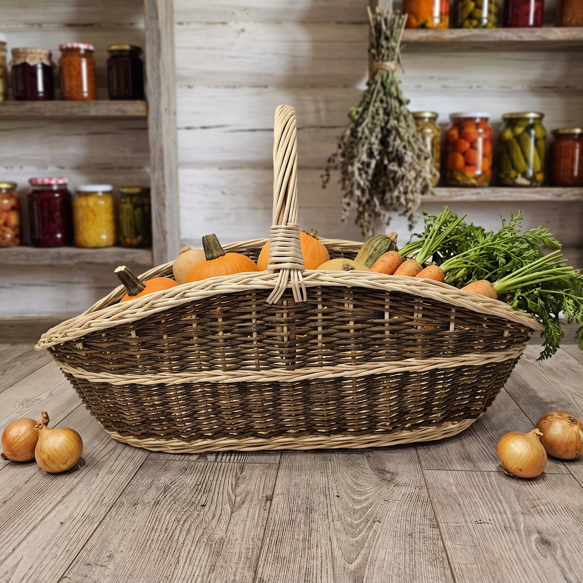 Large wicker harvest carrier holding pumpkins, carrots and greens on a wooden floor in a pantry with shelves of preserves and dried herbs.