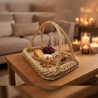 Handwoven willow tray with handles used as a coffee table tray with cheese, grapes and walnuts in a cosy living room lit by candles