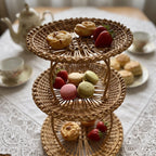 Three-tier willow cake stand serving pastries, strawberries and macarons on a lace tablecloth for afternoon tea