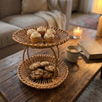 Two-tier wicker cupcake stand with frosted cupcakes on top and chocolate chip cookies below on a living room coffee table