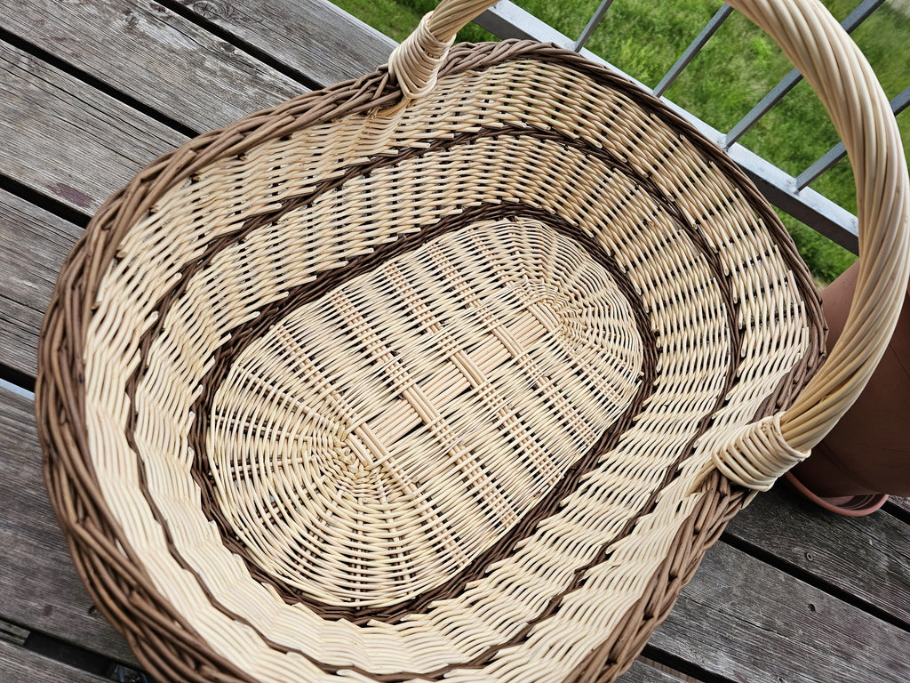 Top view of the extra large wicker trug basket, showing the long oval woven base, the twisted rim and the handle