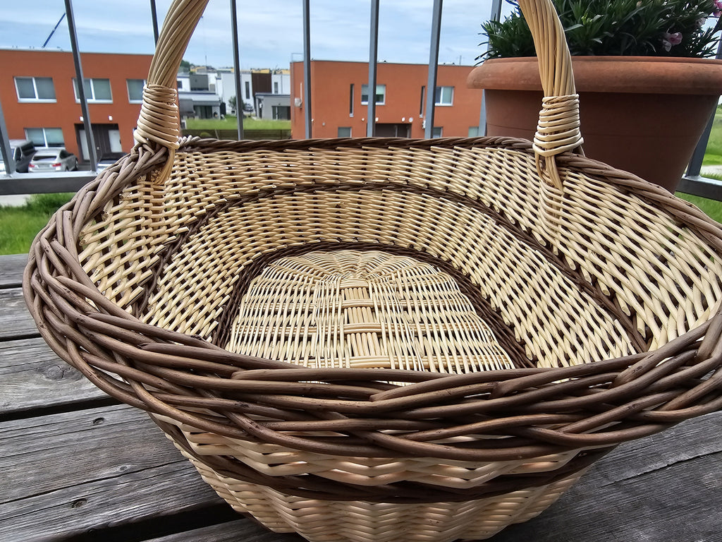 Inside view of the extra large handwoven willow trug, showing the long oval woven base and the twisted rim on a table