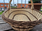 Inside view of the extra large handwoven willow trug, showing the long oval woven base and the twisted rim on a table