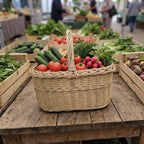 Market basket with handle filled with tomatoes, cucumbers, radishes and herbs on a wooden stall at a farmers market