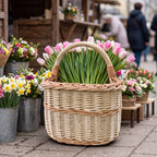 Wicker basket with handle filled with tulips at an outdoor flower market next to buckets of daffodils