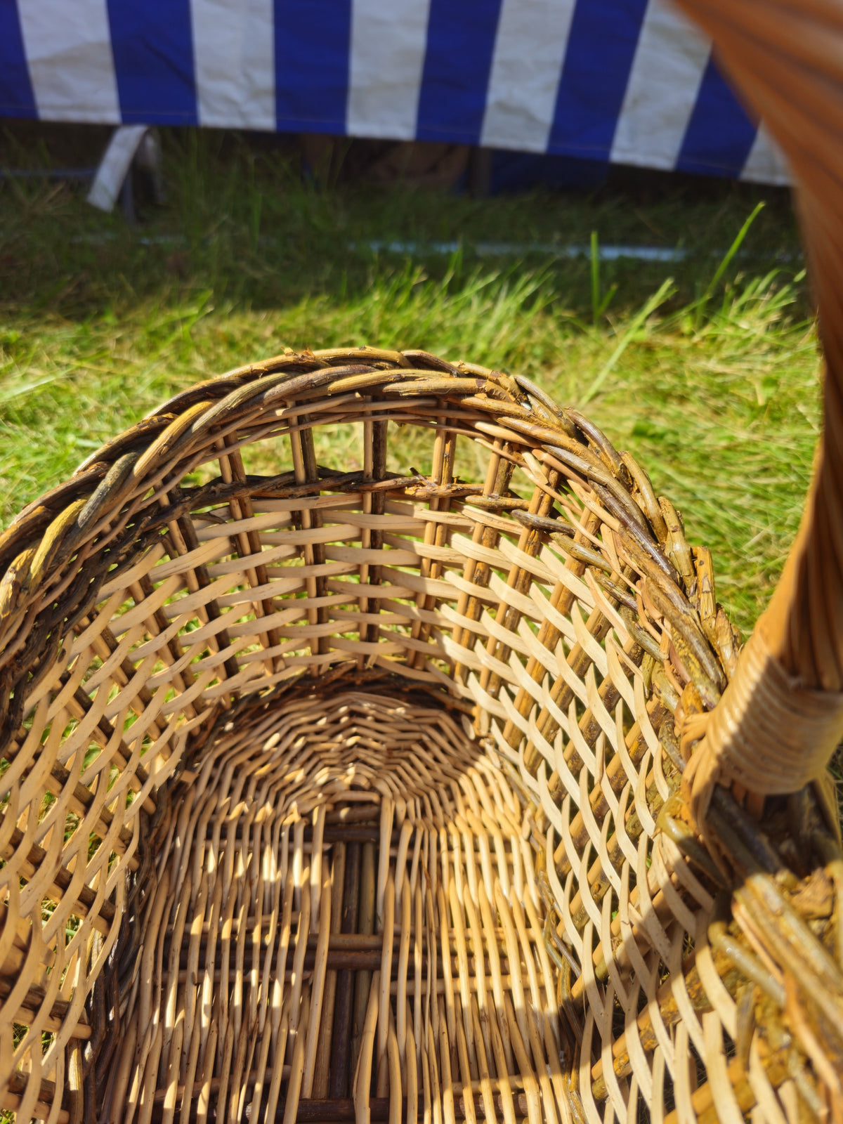 Close-up inside the handwoven willow bread basket showing the woven base and the tight weave of its oval sides.