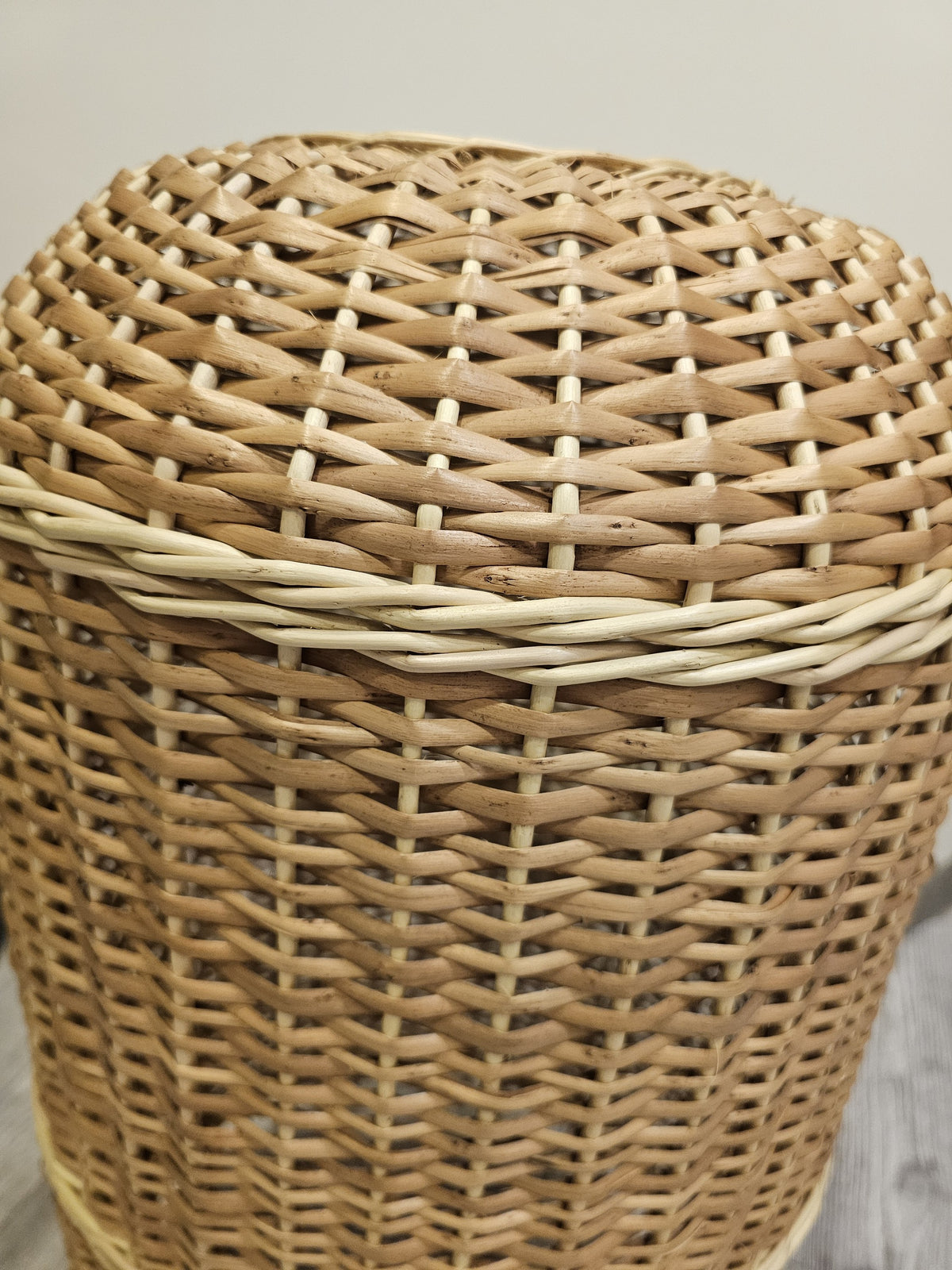 Close-up of the tall willow gas bottle cover showing the domed top, the reinforced band and the tight hand-woven texture of the rods