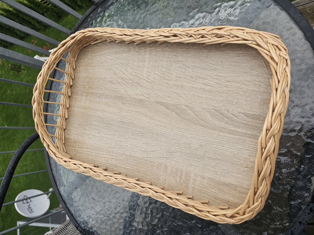 Top view of the handwoven willow tray with wooden base, showing the braided rim and the open-work ends for an easy grip