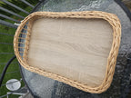 Top view of the handwoven willow tray with wooden base, showing the braided rim and the open-work ends for an easy grip