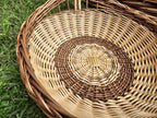 Close-up of the willow trug's round woven base spiralling out from the centre inside the rope-like braided rim