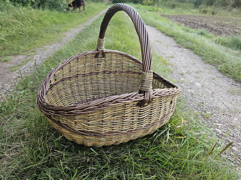 Three-quarter view on the gravel track, showing the depth of the basket and the height of the handle.