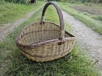 Three-quarter view on the gravel track, showing the depth of the basket and the height of the handle.