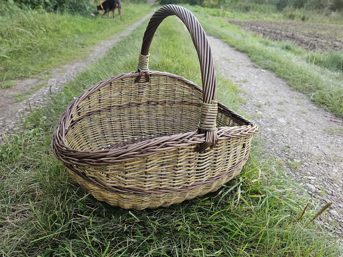 Three-quarter view on the gravel track, showing the depth of the basket and the height of the handle.