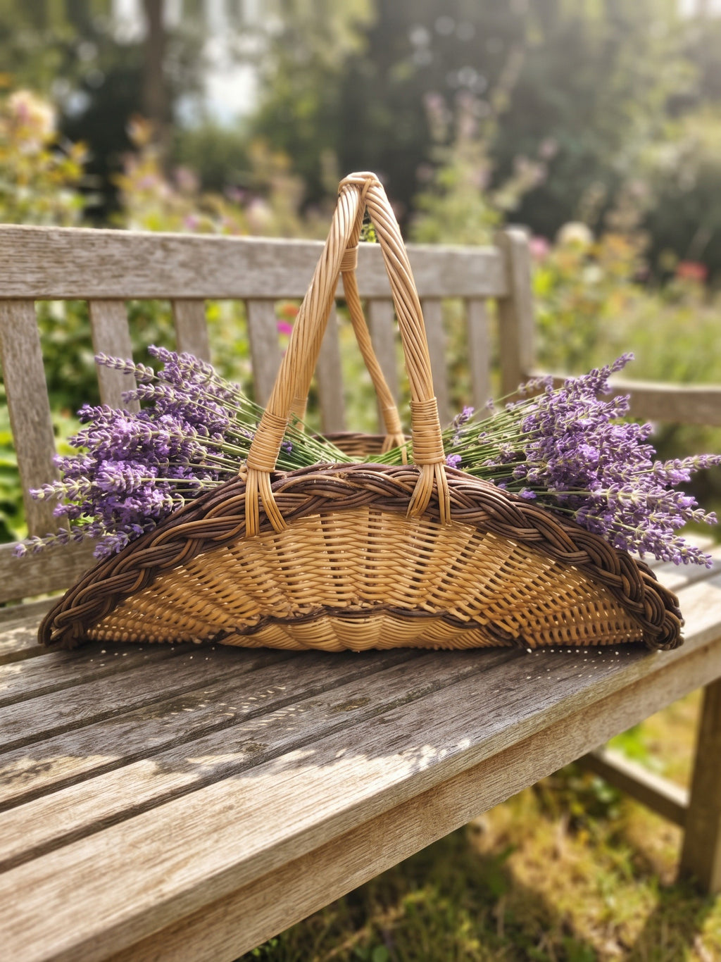 Willow flower trug with a tall arched handle filled with fresh lavender bunches on a weathered wooden garden bench in summer.