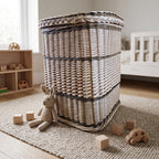Square wicker toy storage basket with lid in a nursery with a knitted bunny, wooden blocks and a toy car on a rug