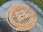 Round openwork willow tray with a diagonal lattice centre and plaited rim, top view