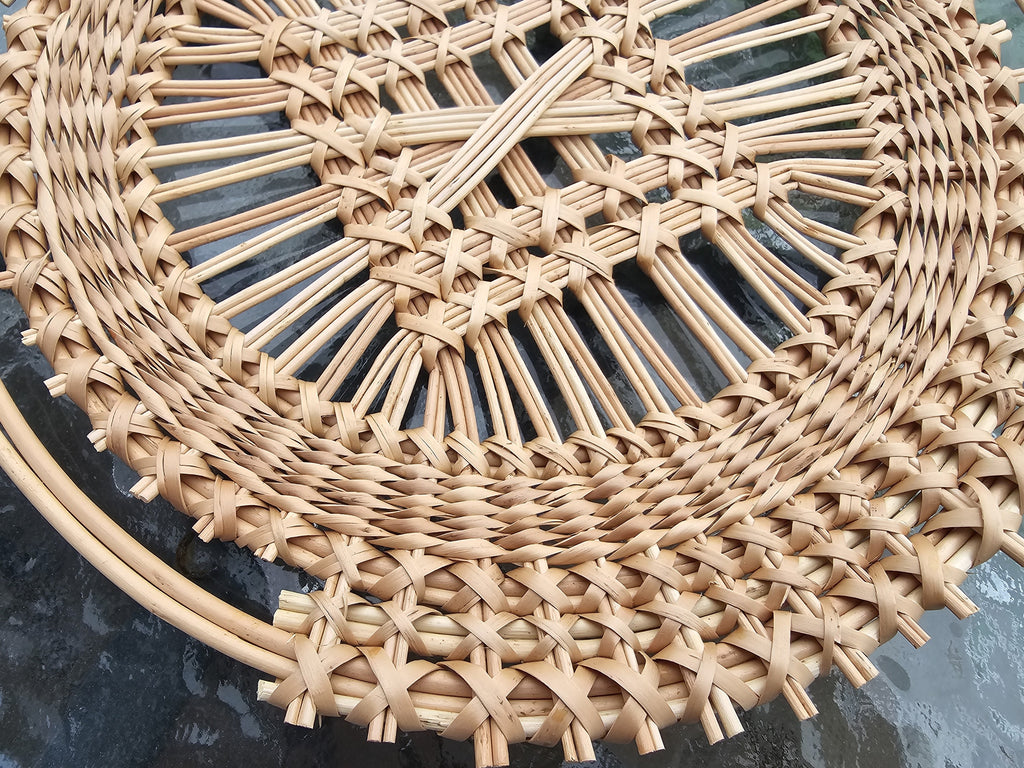 Close-up of the diagonal lattice weave and plaited border of a handwoven willow tray