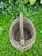 Overhead view with the arched handle running across the mouth, showing how it is twisted from several rods and bound at the join.