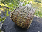 The basket tipped onto its side on rock, showing the closed weave of the wall and the shaping of the base.