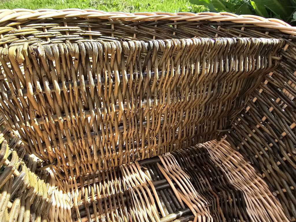 Close-up inside the large handwoven willow basket, showing the woven divider wall and the multi-directional weave of the sides