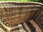 Close-up inside the large handwoven willow basket, showing the woven divider wall and the multi-directional weave of the sides