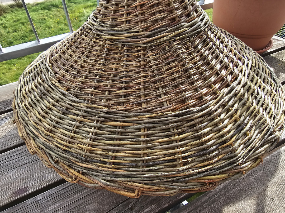 Detail of the tight hand weave on the wide brim of the willow bird feeder roof