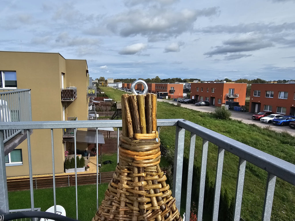 Close-up of the roof peak: bundled willow rods tied with willow and a metal ring for hanging