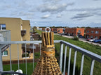 Close-up of the roof peak: bundled willow rods tied with willow and a metal ring for hanging