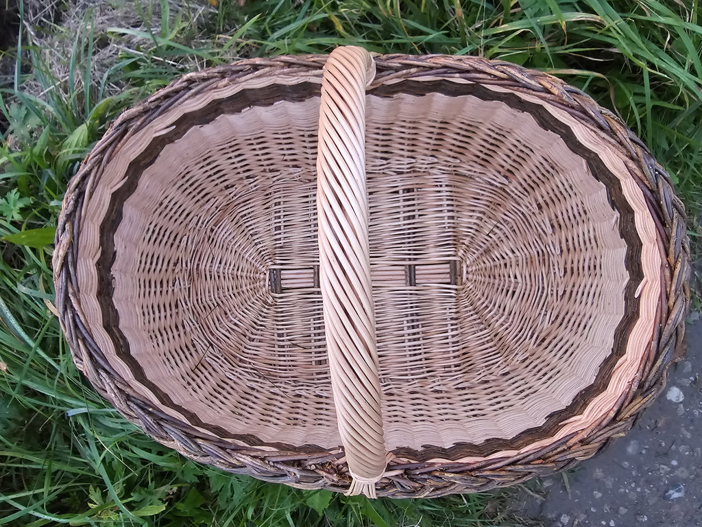 Top view inside the large oval willow basket showing the woven base and the arched handle