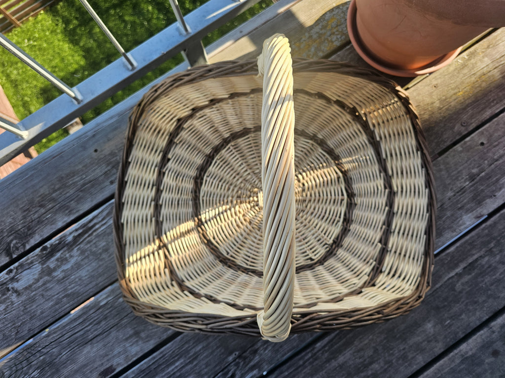 Top view of the large wicker harvest trug for flowers, showing the curved woven base and the tall twisted handle