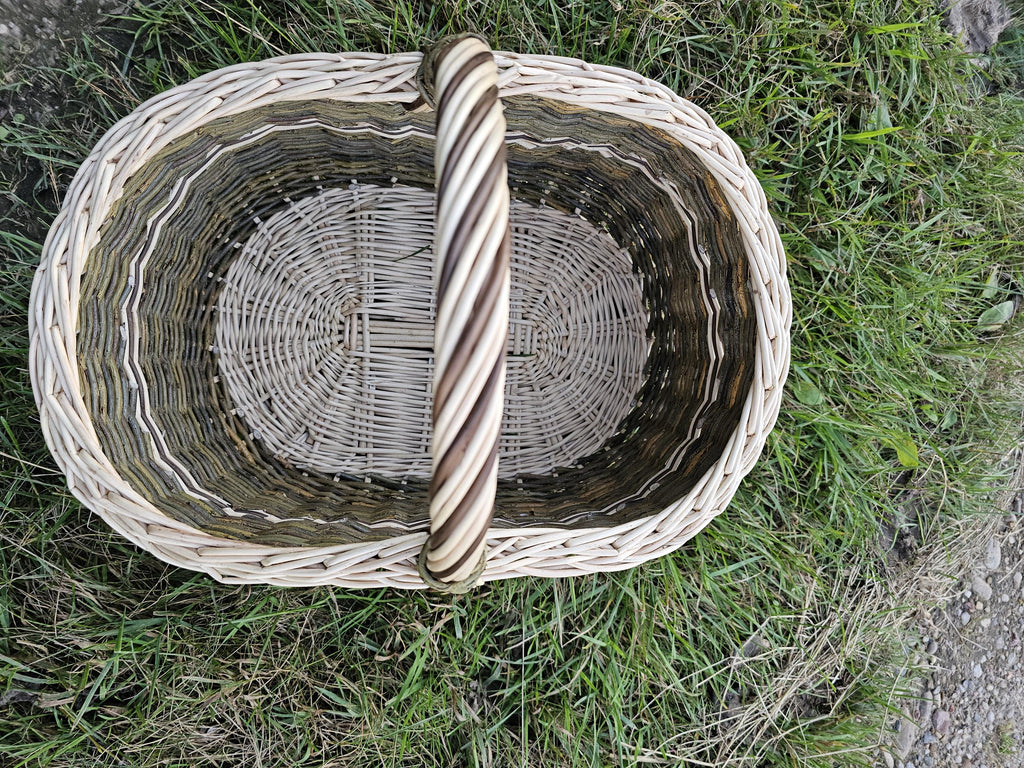 Top view of the willow market basket with the twisted handle laid across the opening
