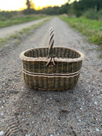 Handwoven willow market basket photographed outdoors on a country track