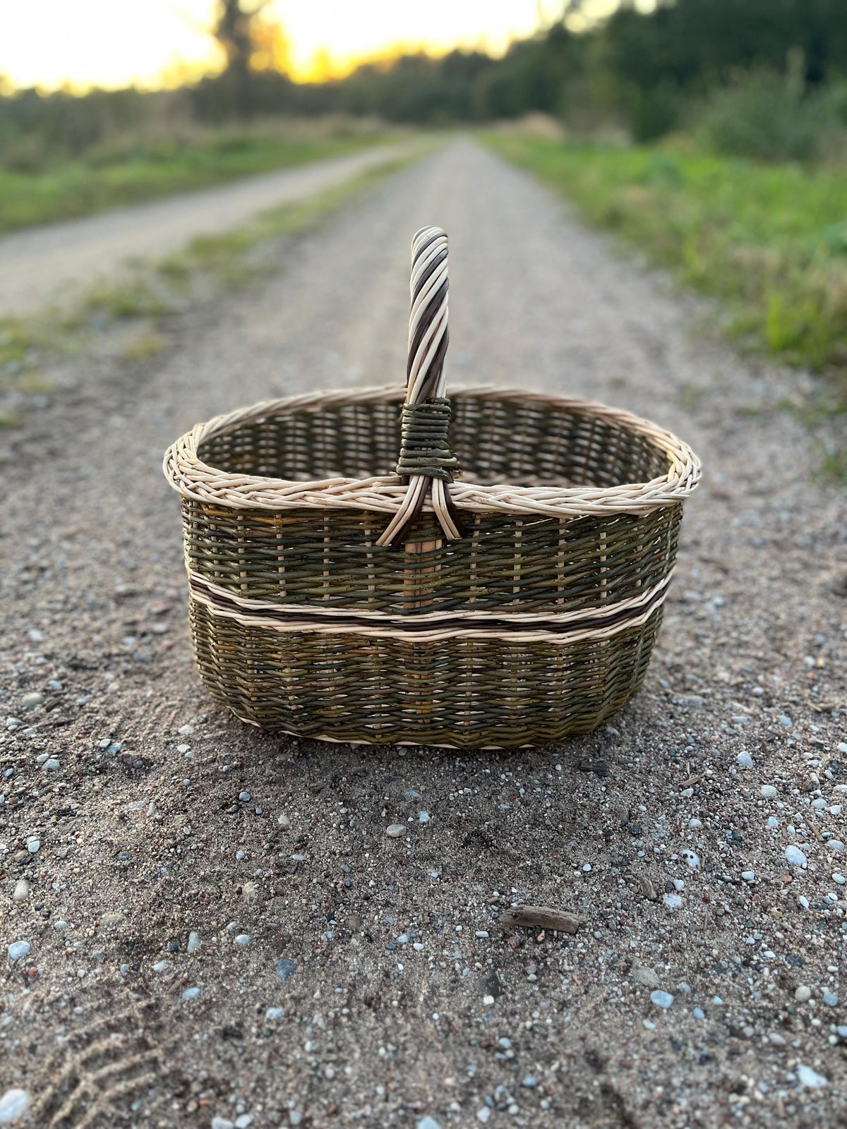 Handwoven willow market basket photographed outdoors on a country track
