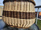 Close view of the side of the oval willow basket, showing the tight even weave of the body down to the base