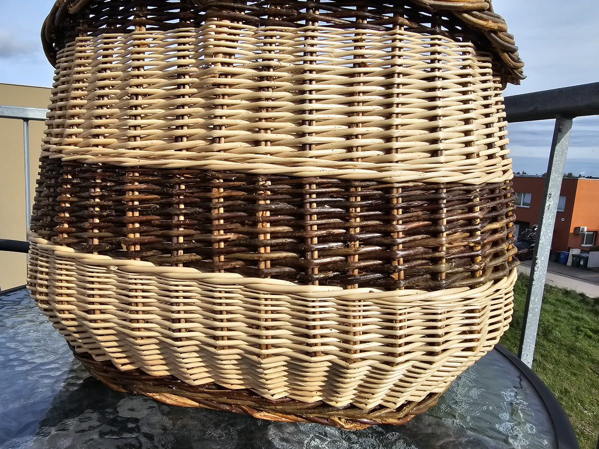 Close view of the side of the oval willow basket, showing the tight even weave of the body down to the base