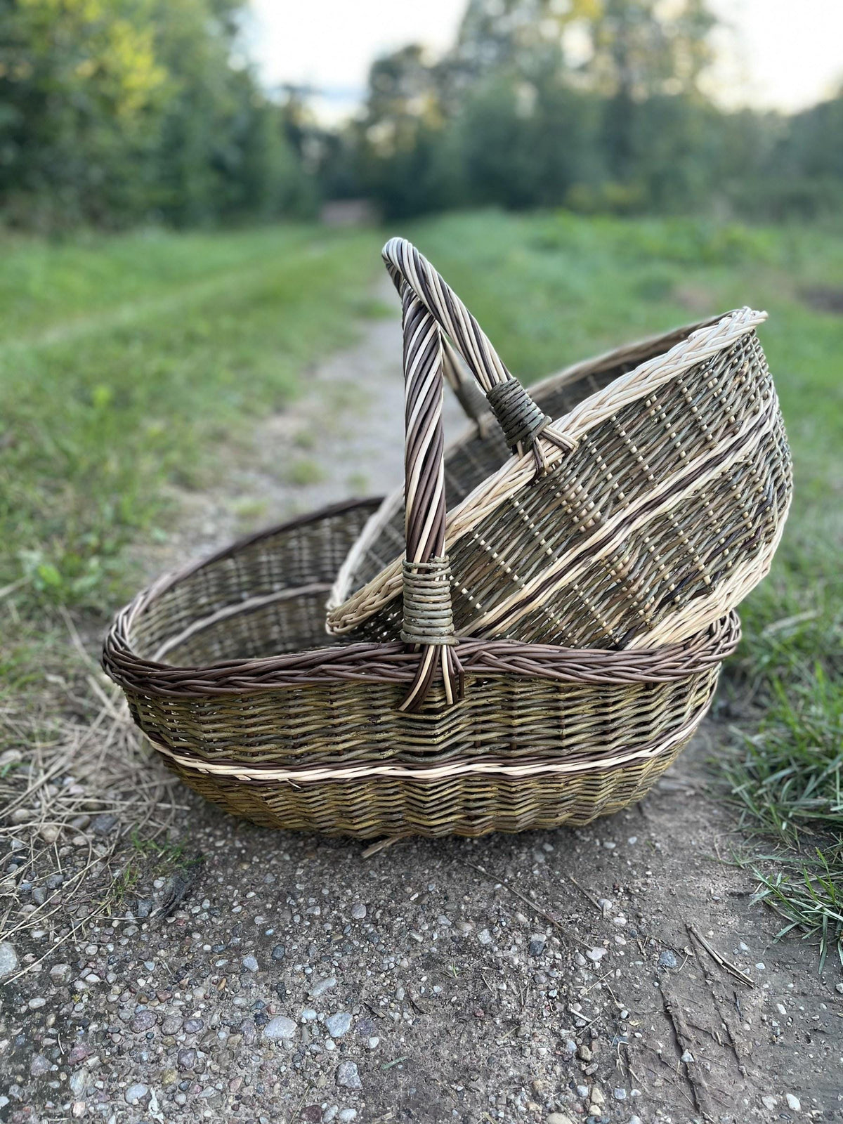The small basket resting inside the large one on a gravel path