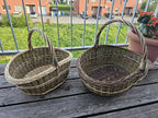 Both willow baskets side by side on a wooden bench, showing the difference in size