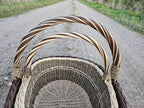 Close view down onto the nested pair, the twisted handles arching above the plaited rims