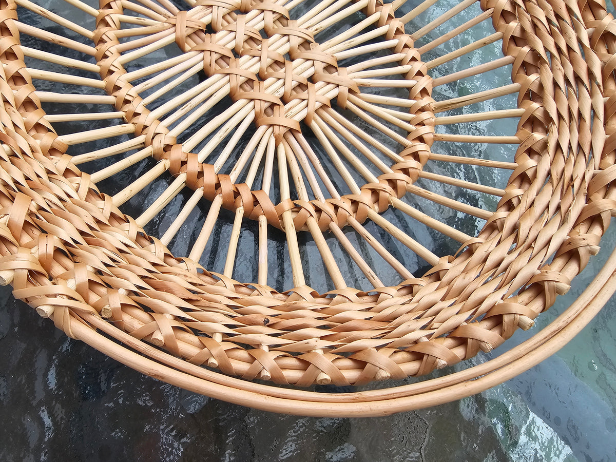 Close-up of the lattice centre, upright rods and plaited rim of an openwork willow tray