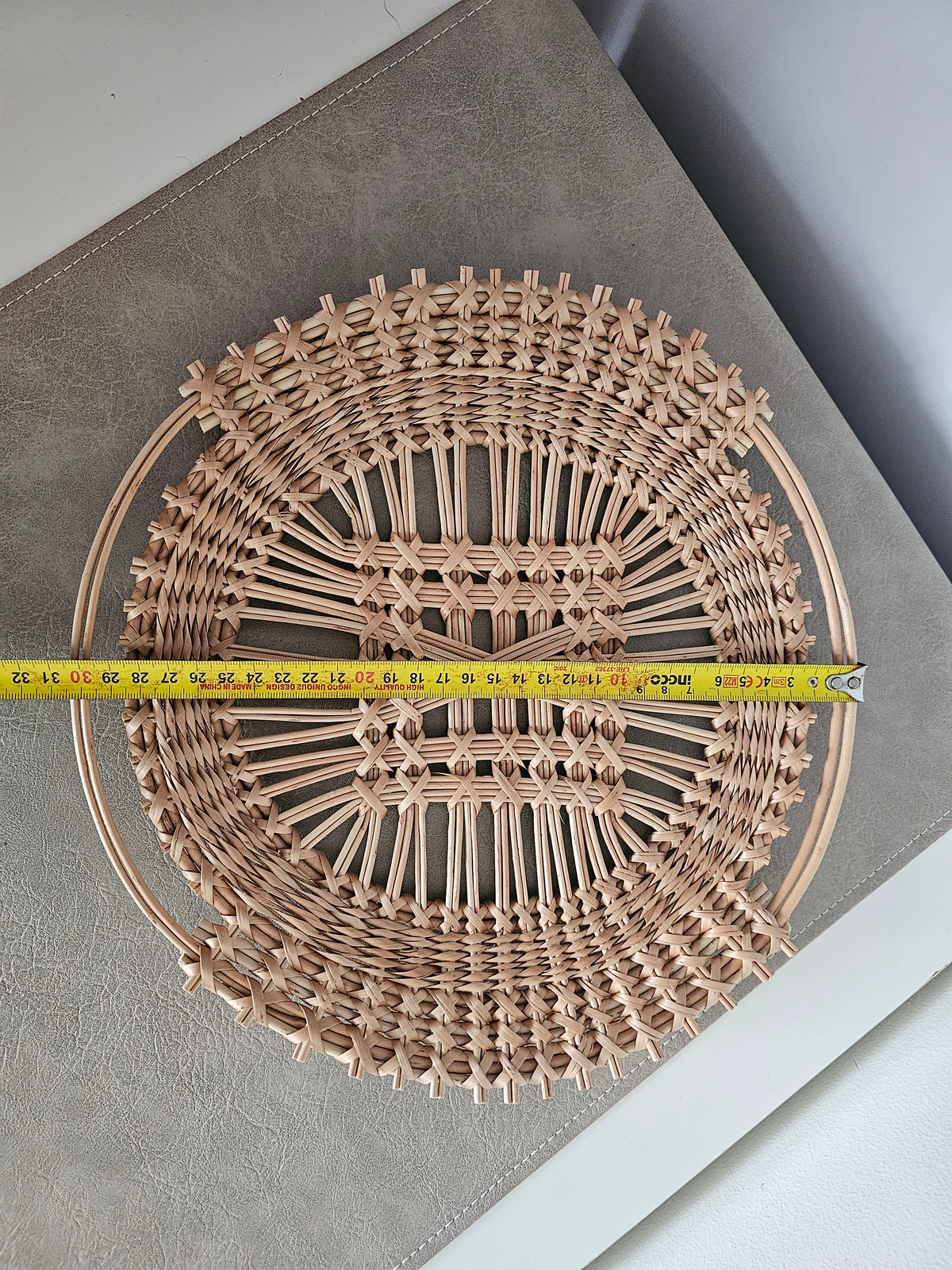 Openwork willow tray measured across with a tape measure, about 30 cm in diameter