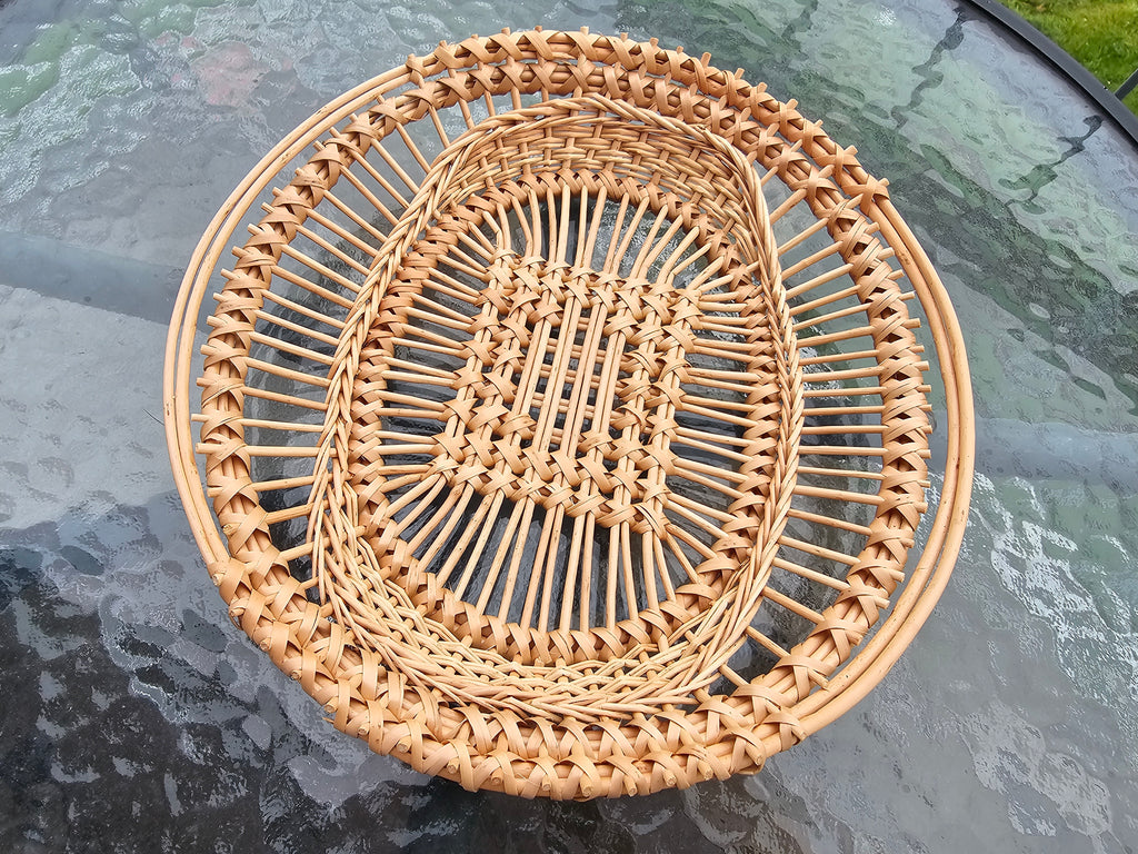 Oval openwork willow tray with a lattice centre and open rings of upright rods, top view
