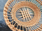 Close-up of the sloped side and lattice centre of a handwoven willow tray