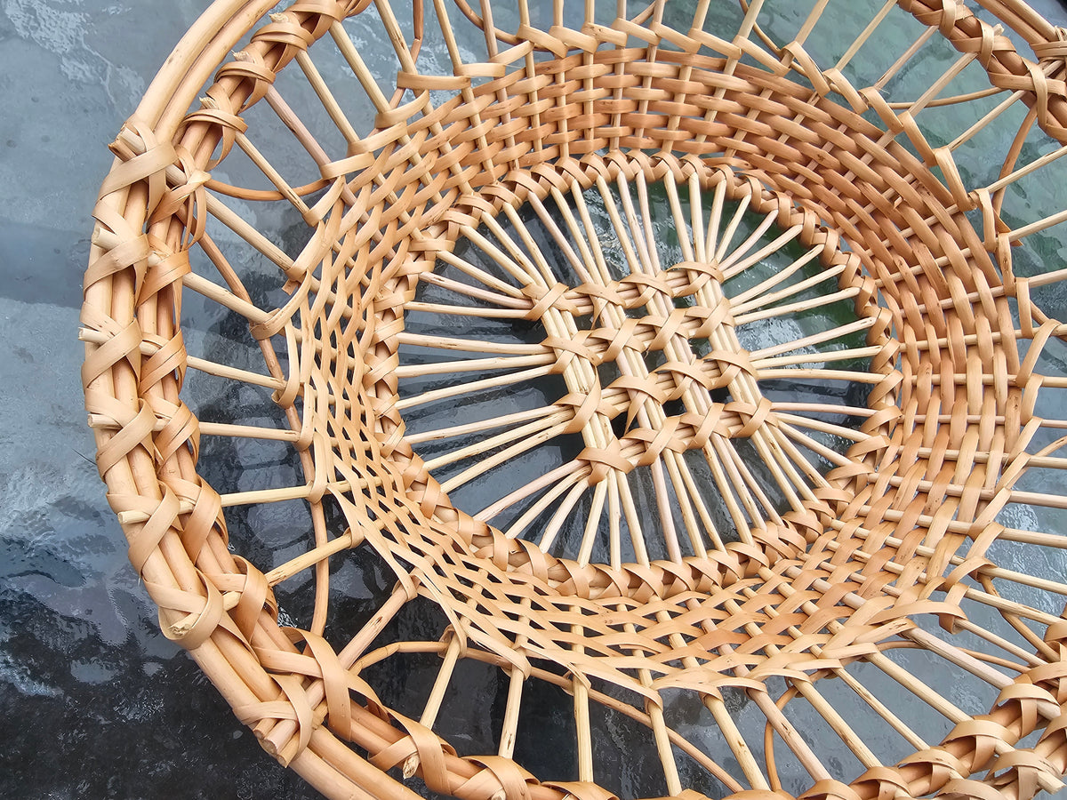 Close-up of the sloped side and lattice centre of a handwoven willow tray