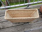 Narrow willow storage basket seen from above, showing its long slim shape and wooden base