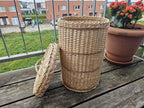 Willow bin with the lid removed and leaning against its side, showing the open top and raised woven bands