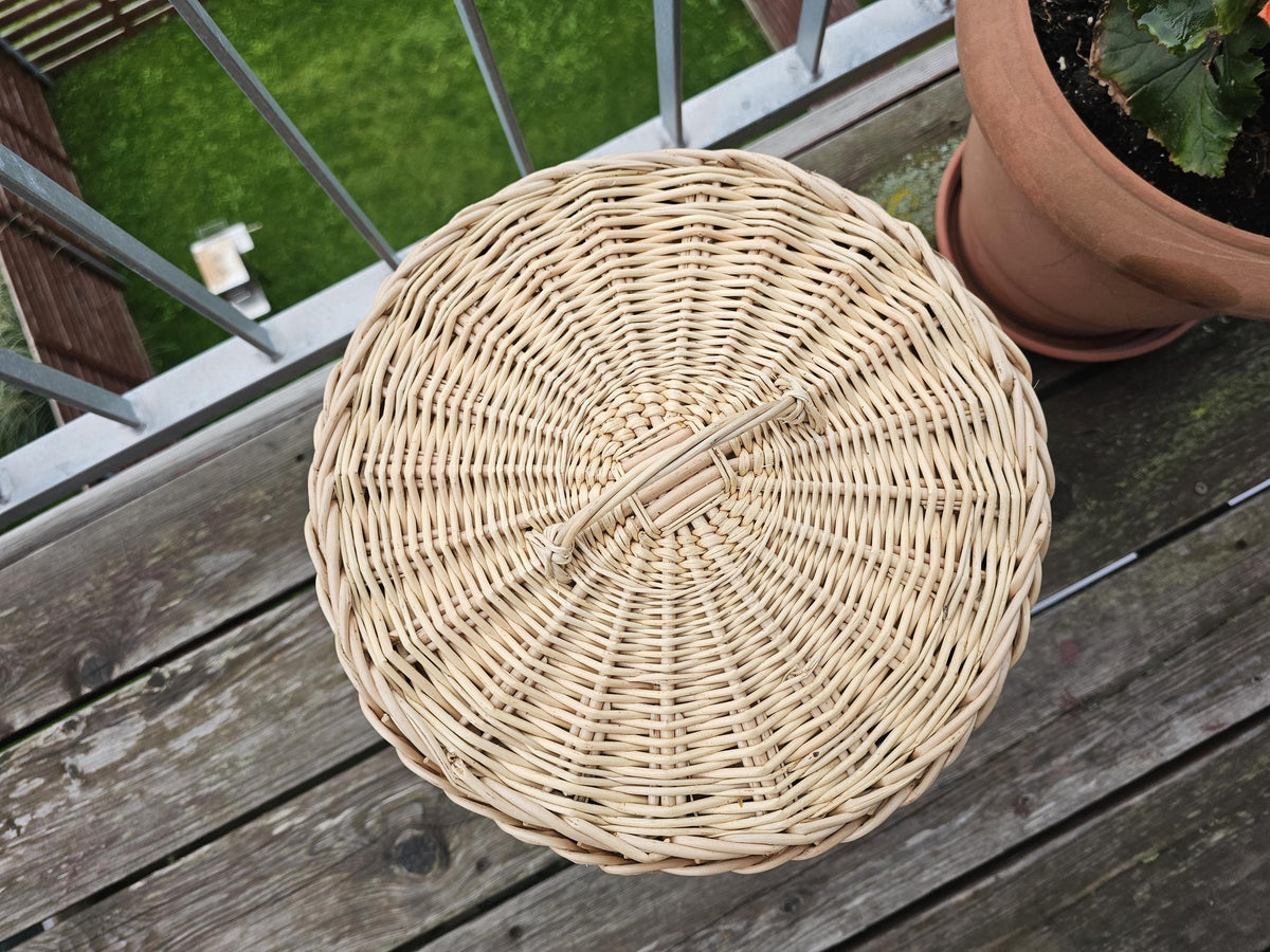 Top view of the round woven willow lid with arched handle