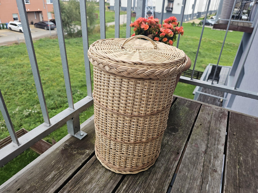 Lidded willow basket from a low angle showing the woven bands and plaited rim